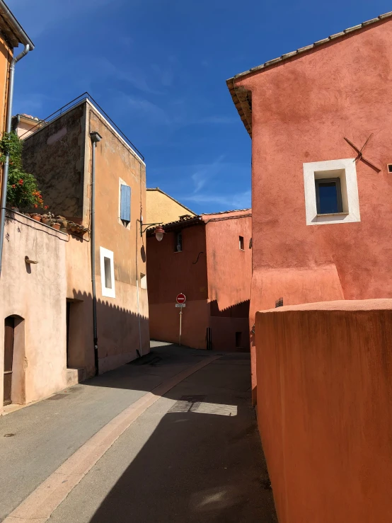 narrow alley way with buildings and a cross on top