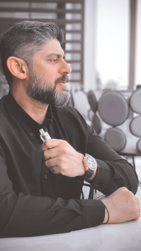 a man sitting on the ground and using a white electronic device