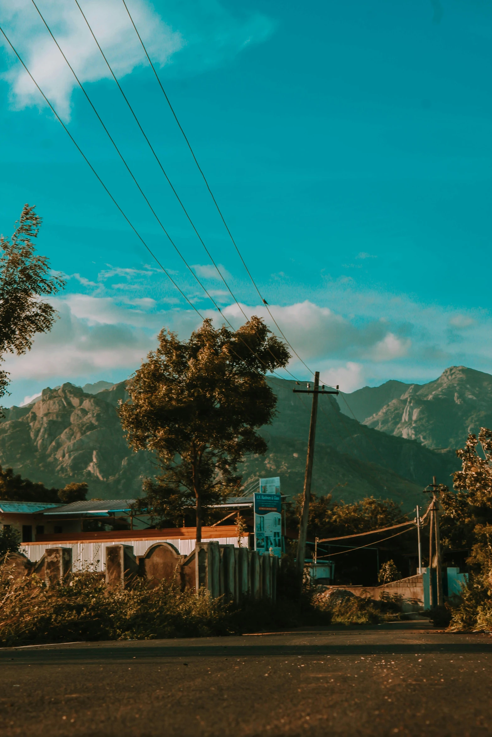 an outhouse on the side of the street with mountains in the background