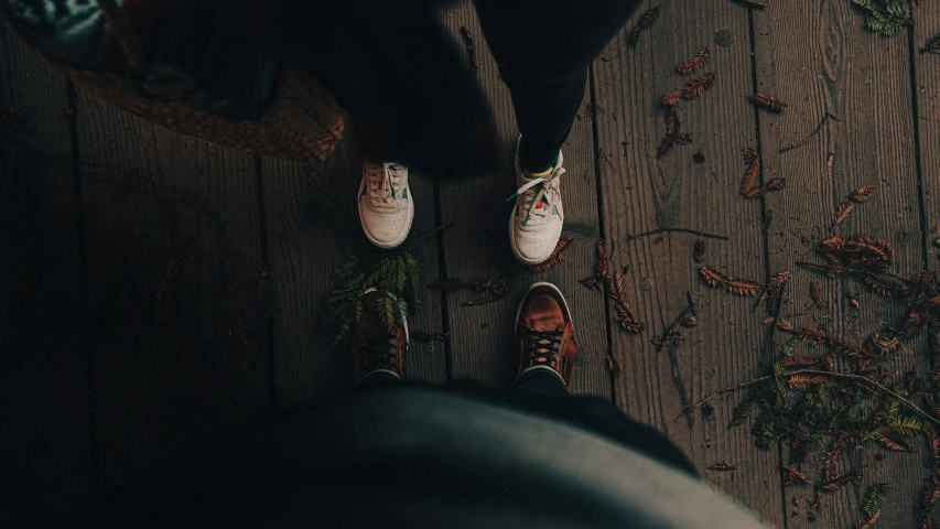 person sitting on the ground next to some brown leaves