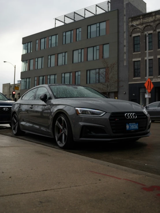 the grey car is parked at the curb