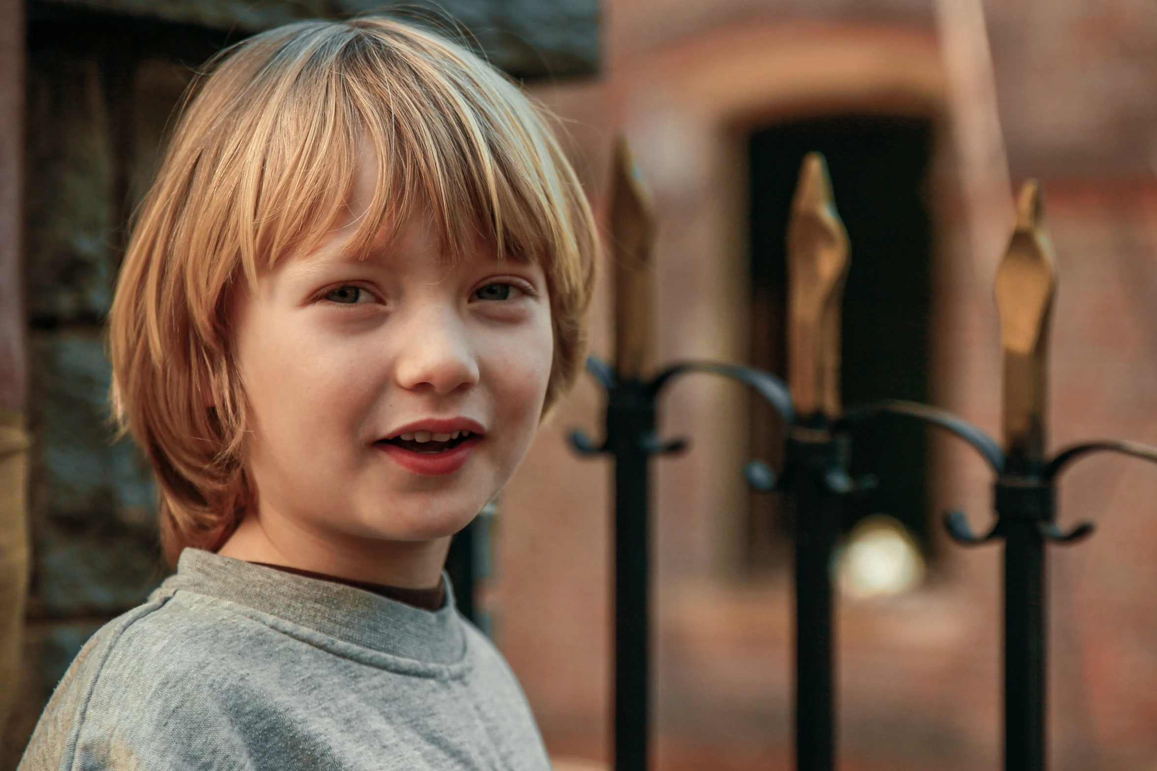 there is a child that is smiling by the gate