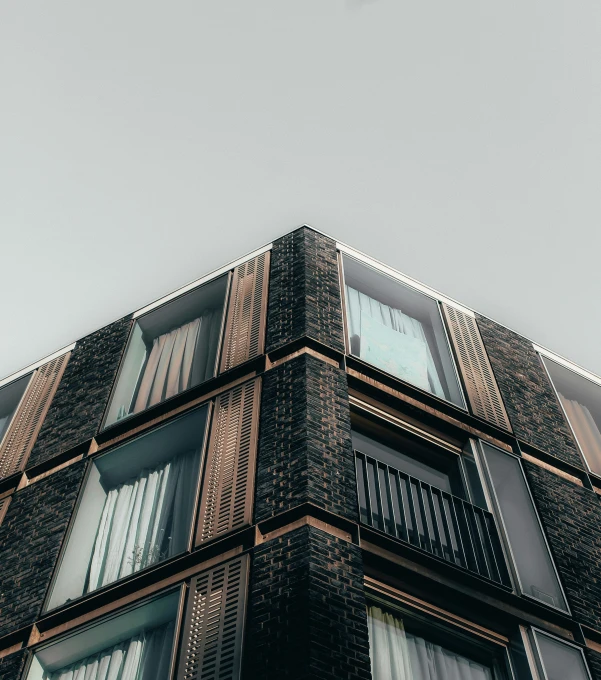 the corner of a brown building with lots of windows