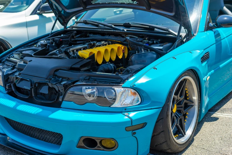 blue bmw is shown with engine and hood
