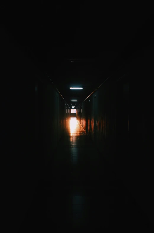 a dark hallway in the middle of the night with light from a candle