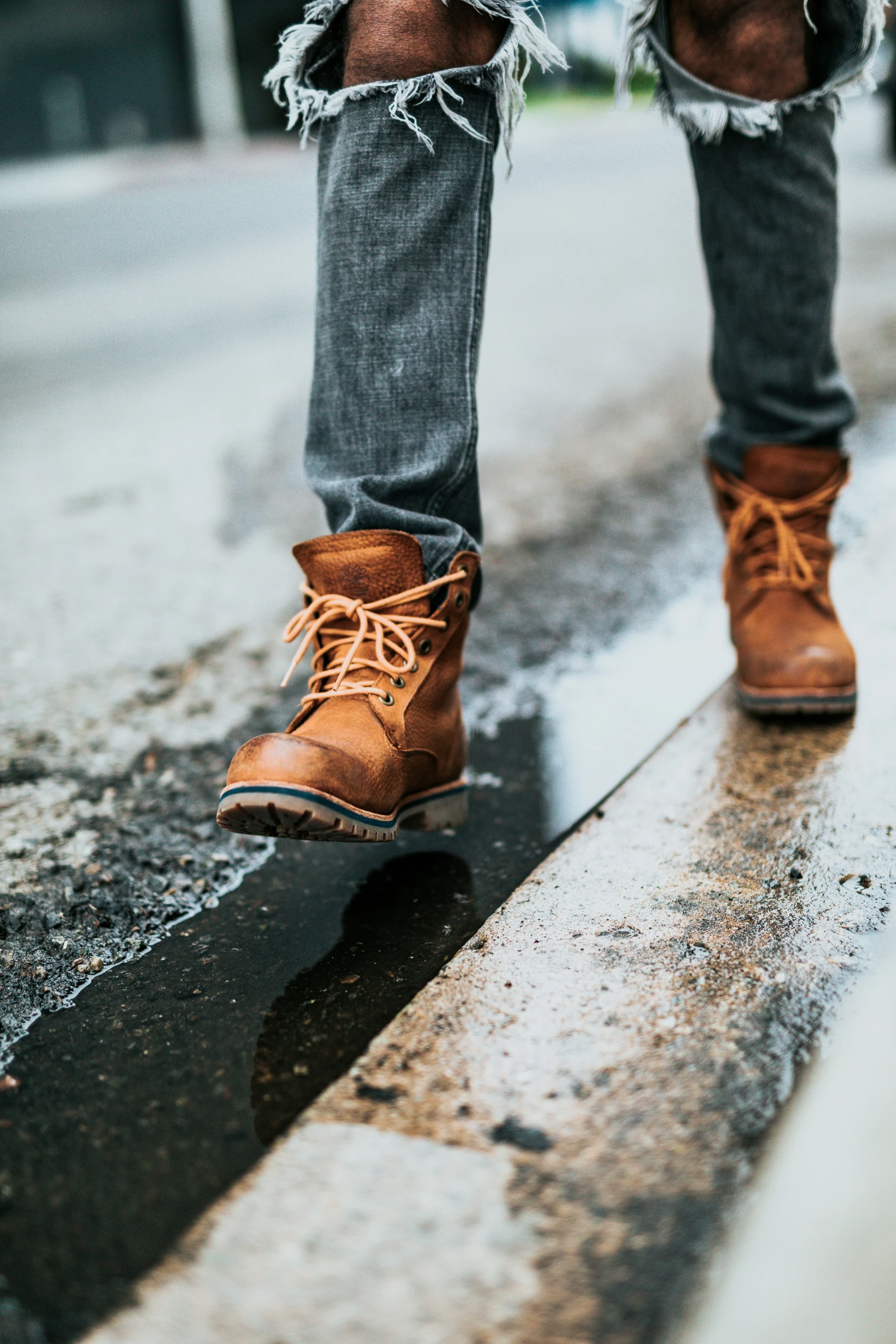 this is someones shoes and jeans standing in the rain