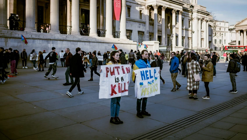 people are gathered in front of a building with picket signs