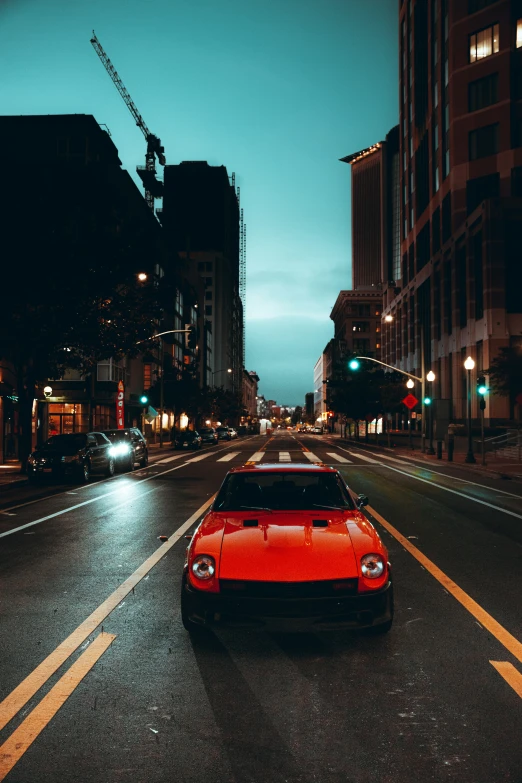 a very pretty red car in the middle of an empty street