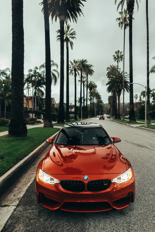 an orange car is parked on the side of a street