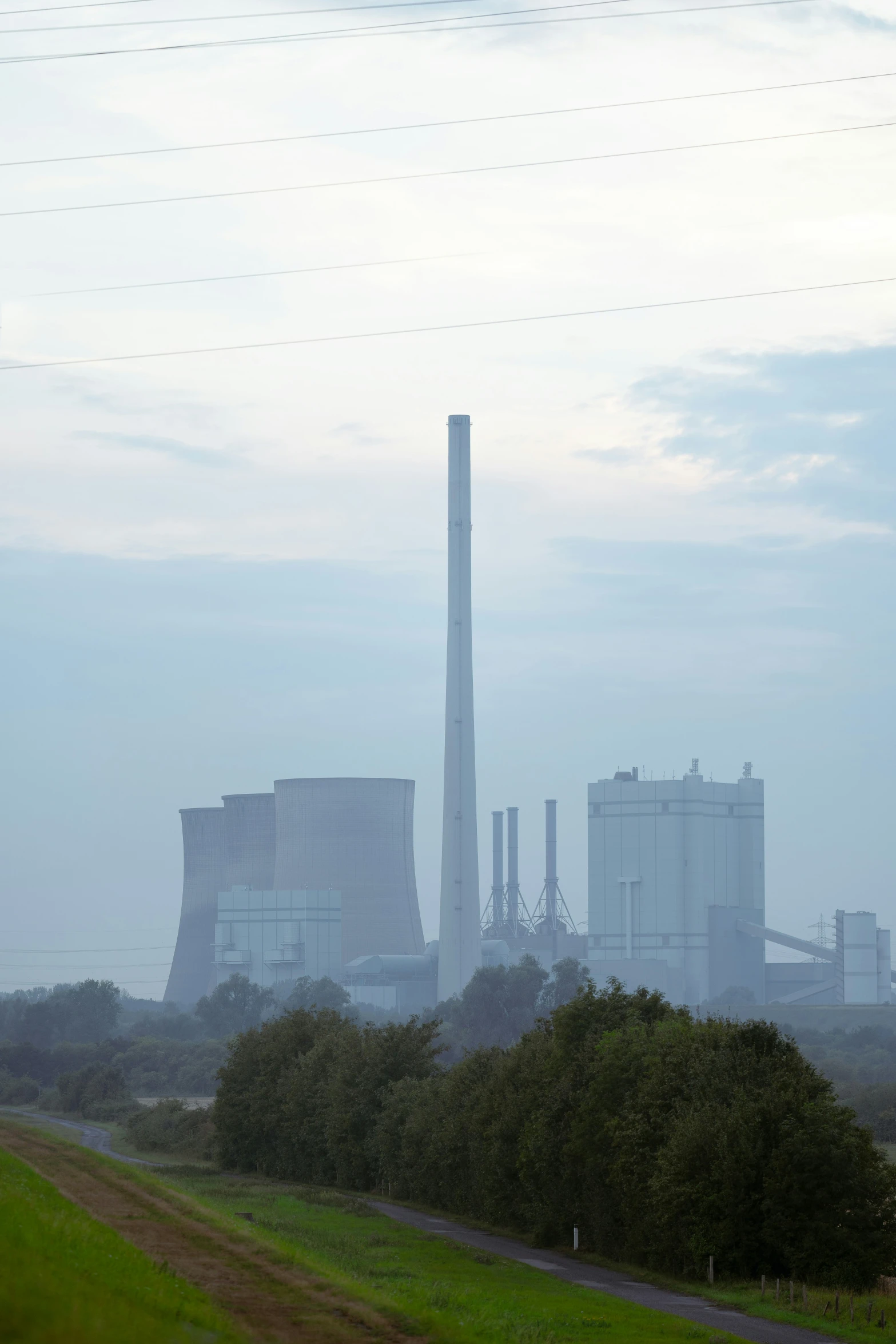 an industrial area in the fog with some power lines