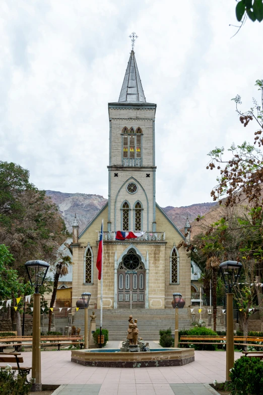 a large church on a hill has a statue sitting in front