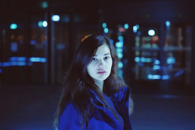 a young woman in a blue coat posing for a po