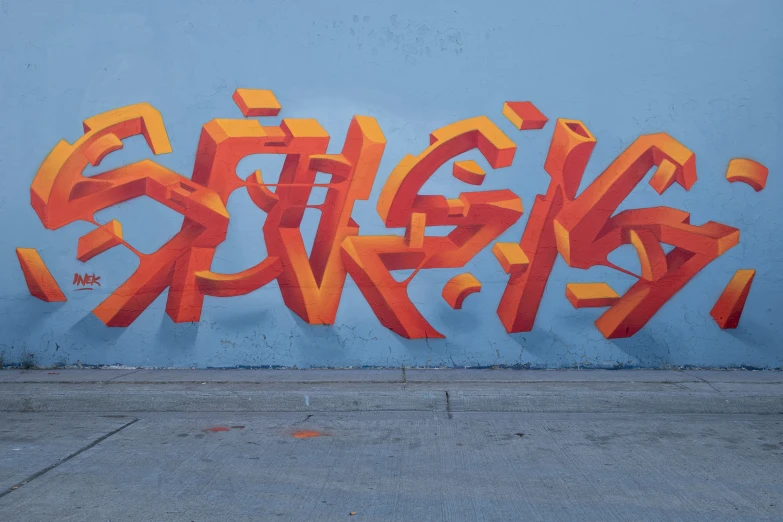 a mural of orange graffiti writing against a blue wall
