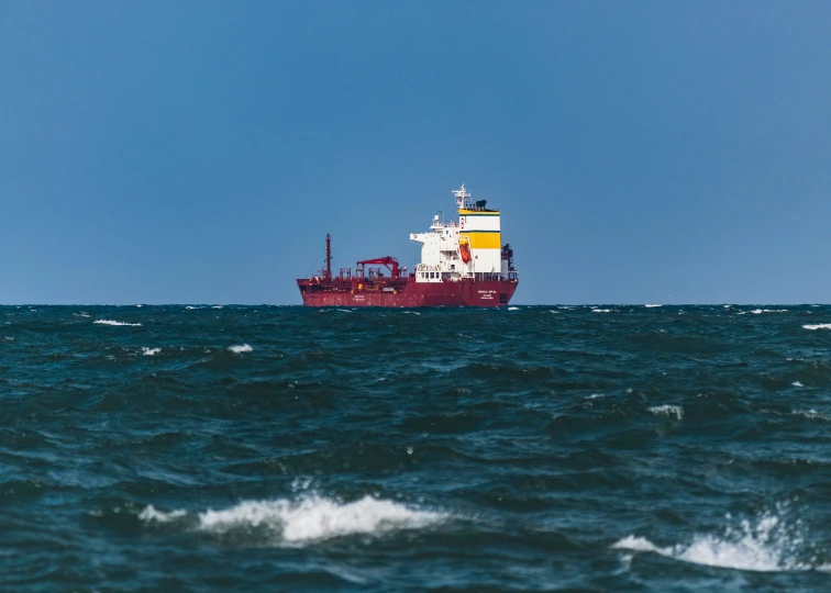 a small red boat in the open ocean