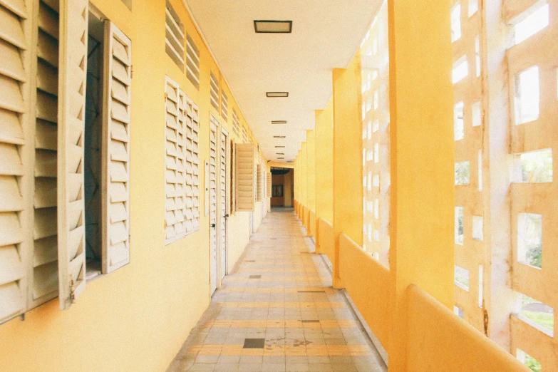 the hallway has several windows and yellow shutters