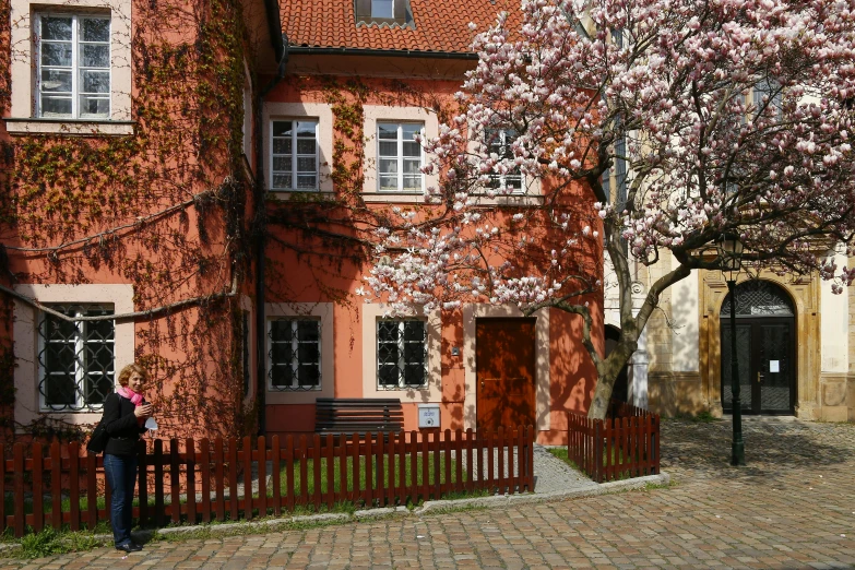 two people are standing in front of a pink house