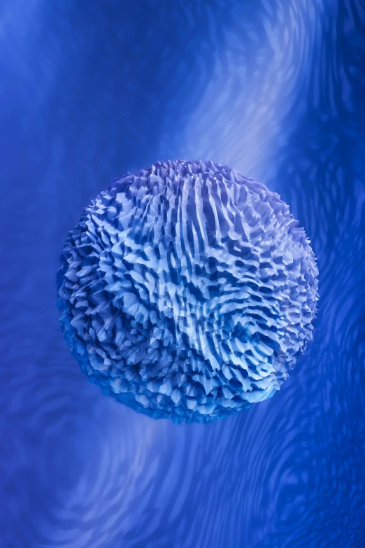 a large blue object floating in a dark pool of water