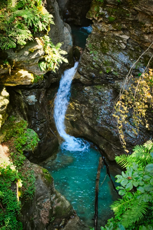 there is a waterfall in the middle of some large rocks