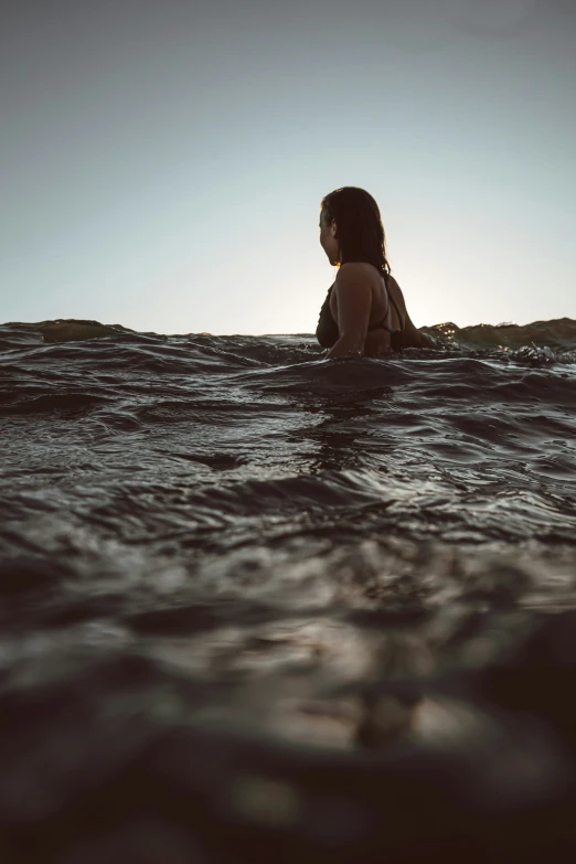 a woman sitting on a surfboard in the ocean