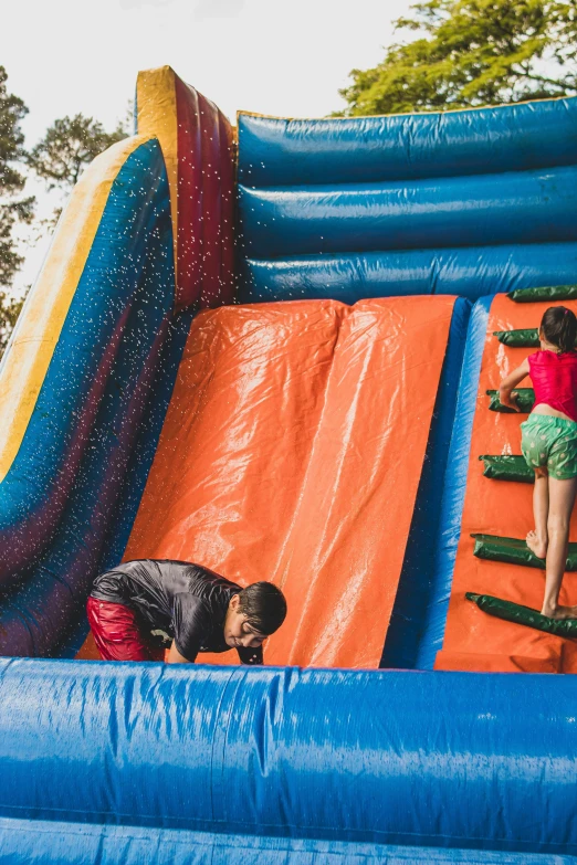 children jump into the pool in an inflatable slide