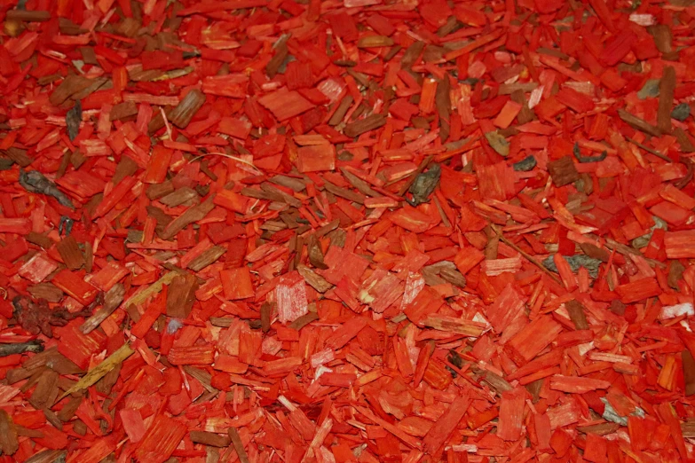 a pile of bright red colored wood chips