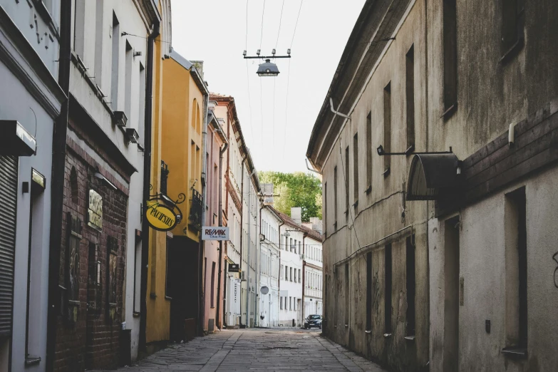 an old fashion street is lined with narrow buildings