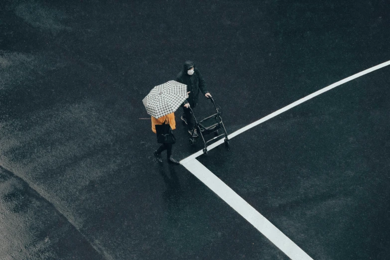 an umbrella stands in the middle of an asphalt area with a person hing a rickshaw