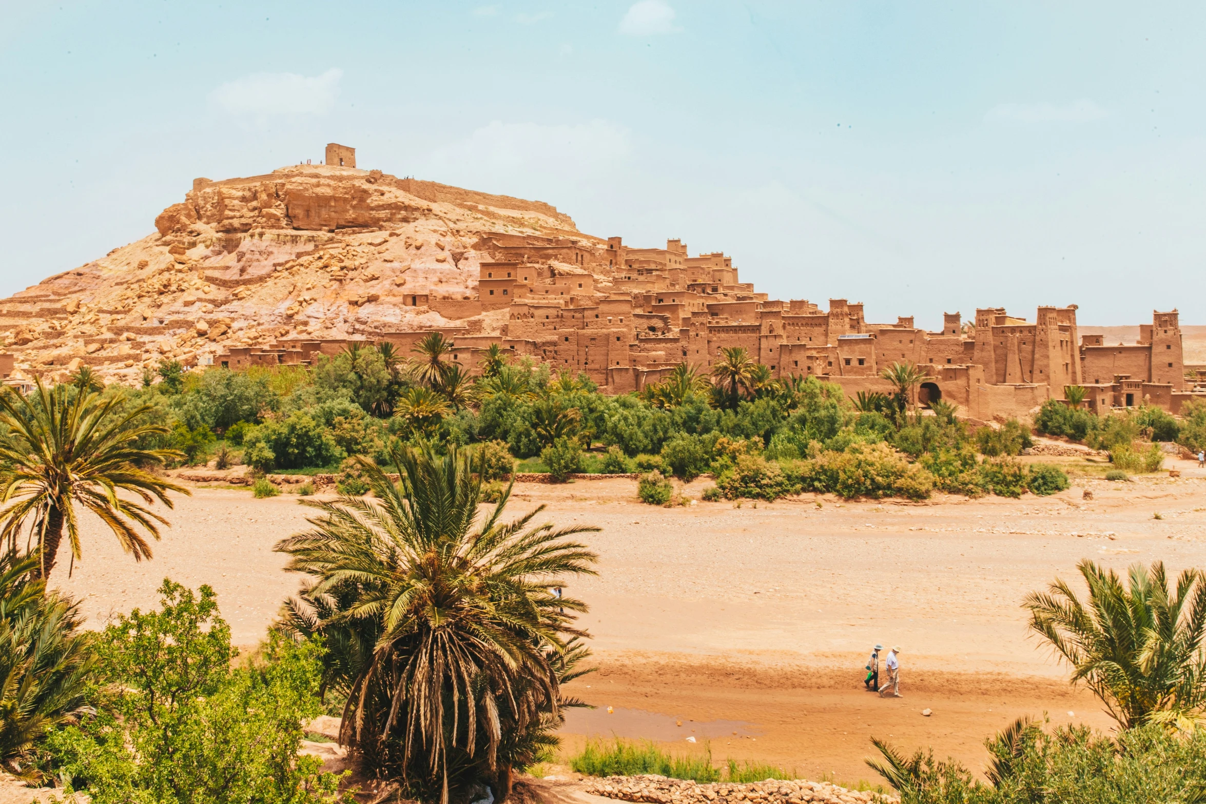 large brown building in desert next to trees