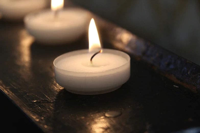 a group of lit candles sitting on top of a wooden table