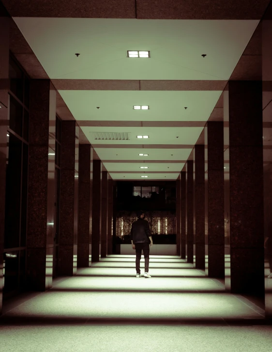 a man standing in the middle of a very long hall