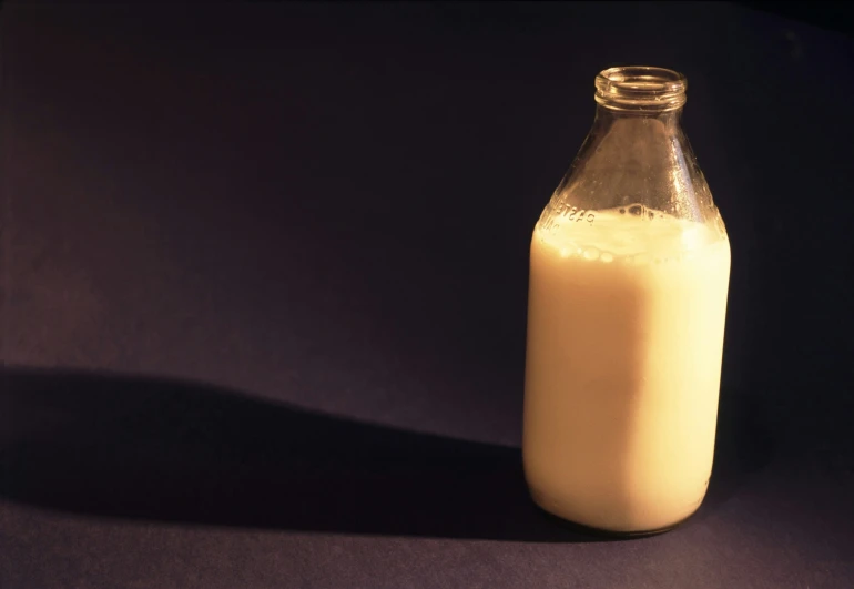 a bottle of milk on a table that is light brown