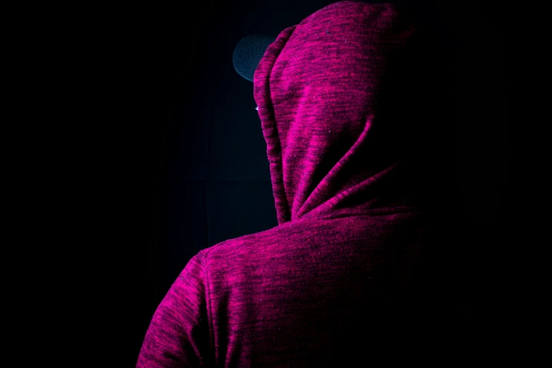 silhouette in dark background wearing hooded jacket