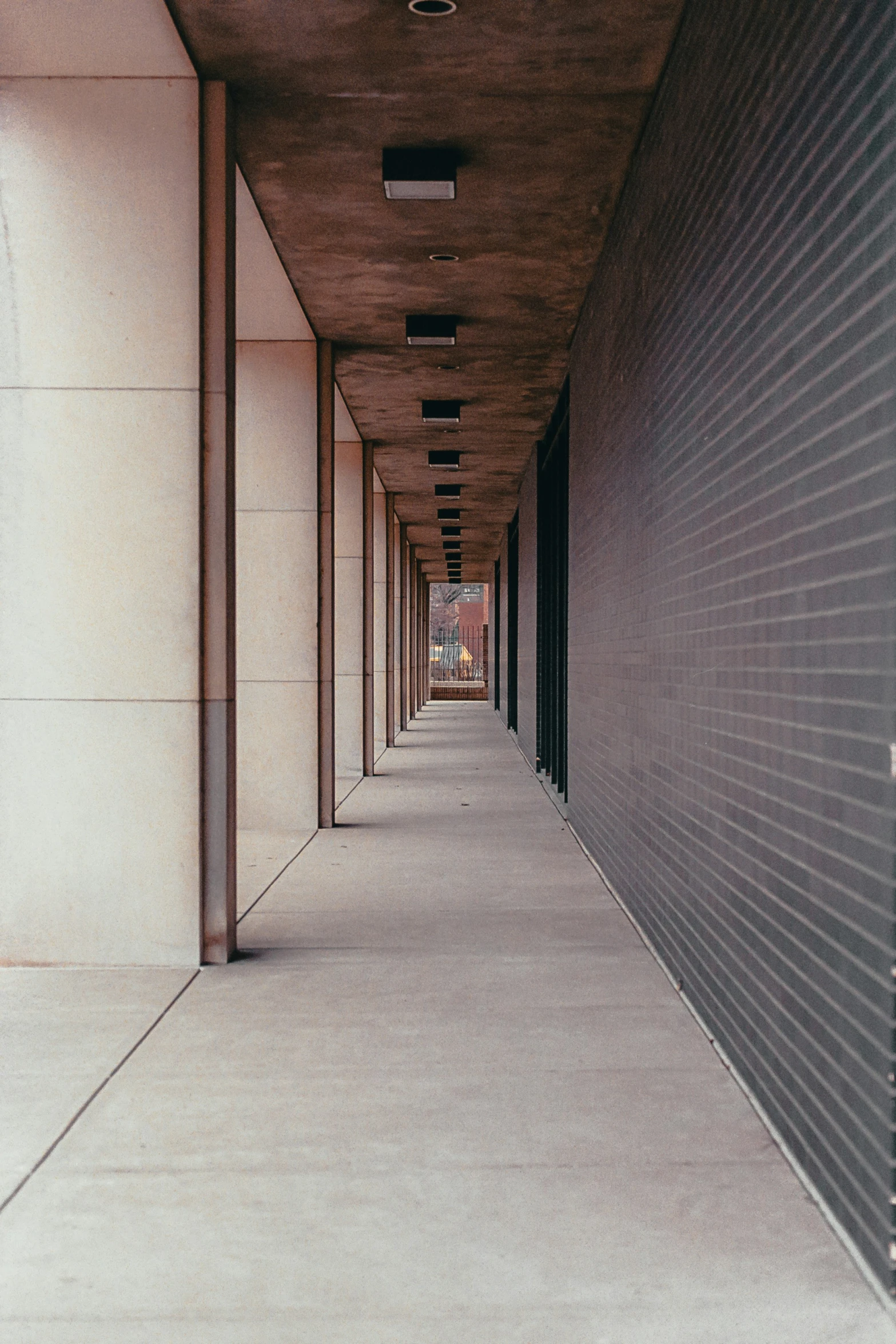 a hallway with several brick sides next to tall building