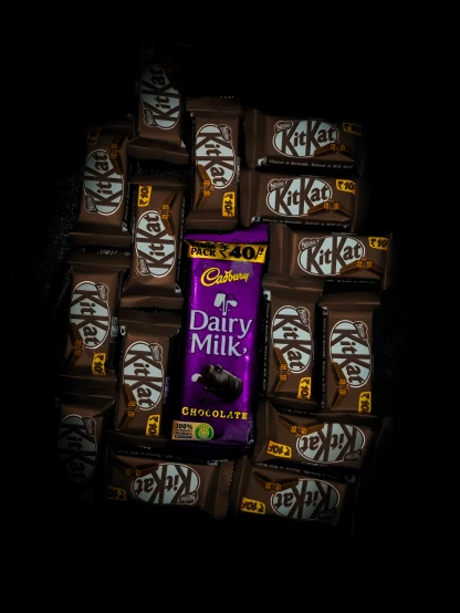 dairy milk chocolate bar sitting on top of other chocolate bars