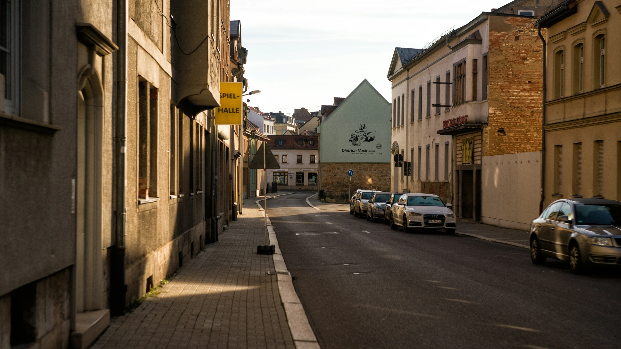 a city street with a couple of cars parked along the side