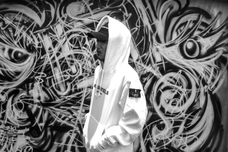 a black and white image of a man with a hoodie on