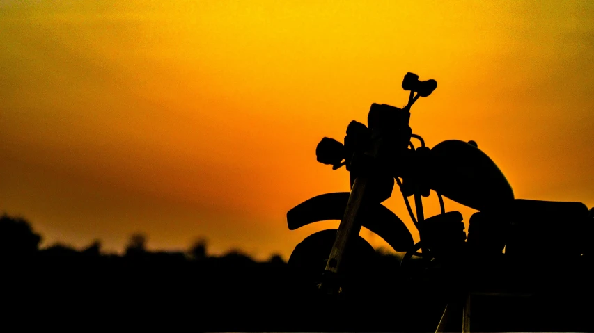 a bike is being watched by the sun behind it