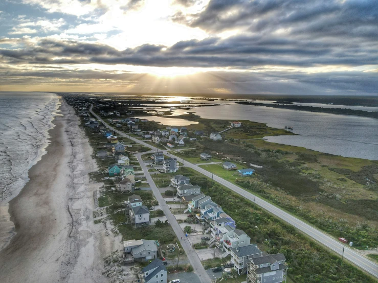 some houses next to the ocean under a cloudy sky