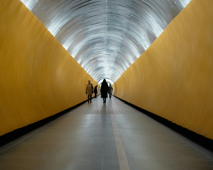 people walking inside a tunnel between the walkway