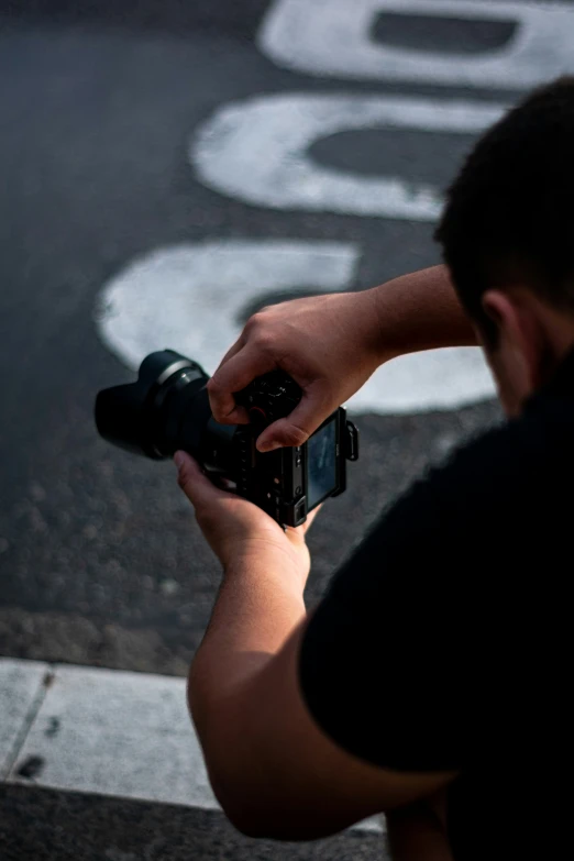 man with black shirt holding camera up to the camera