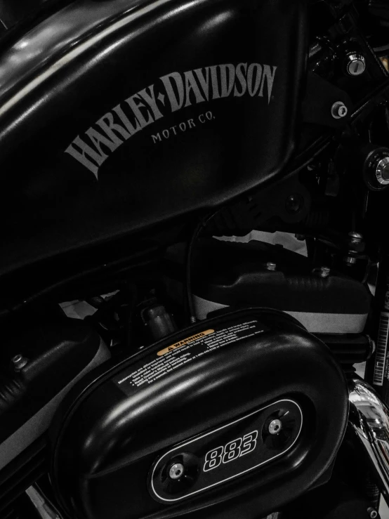 a motorcycle parked near a wall with harley davidson's logo on it