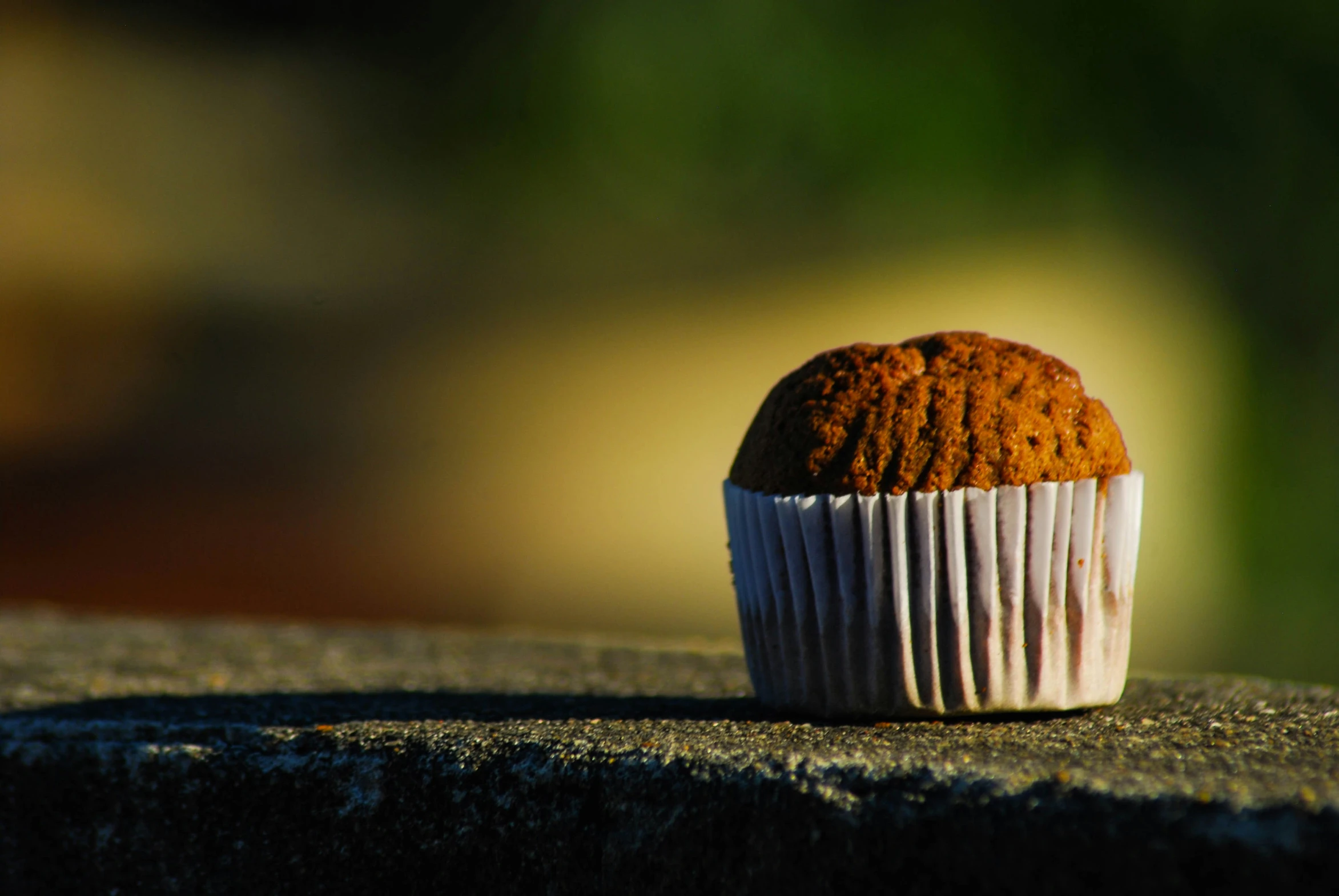 an unpeeled cupcake in a white cupcake liner