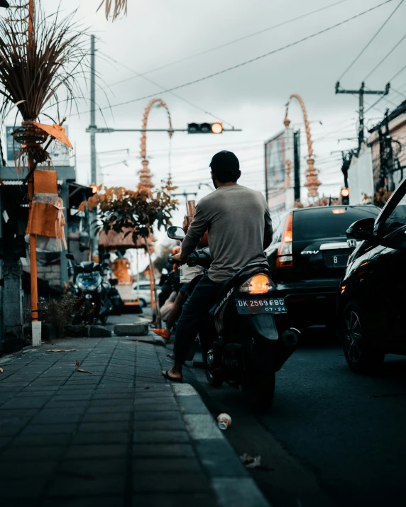 a man riding on the back of a motorcycle down a sidewalk