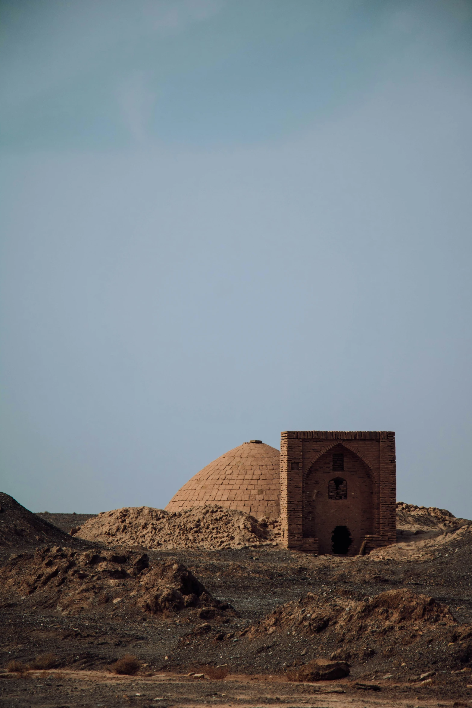 a lone building on the side of a hill