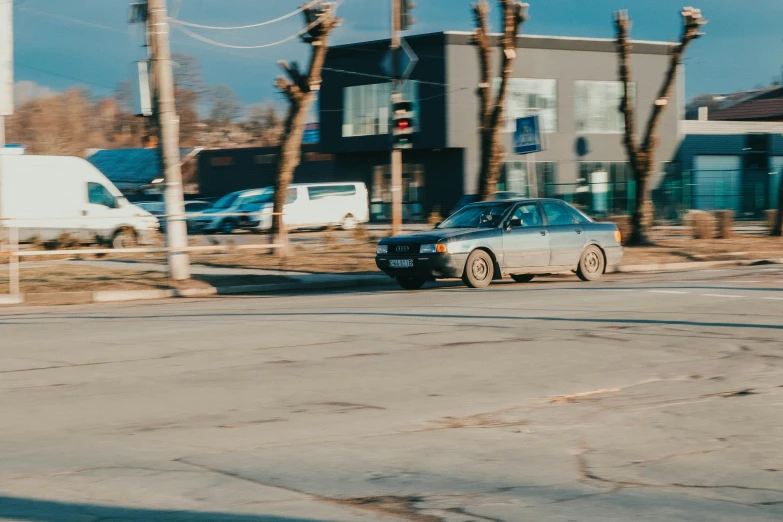 an old, small blue car is parked on a city street