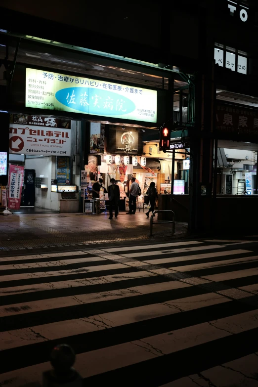 people sitting at tables under signs in an asian market