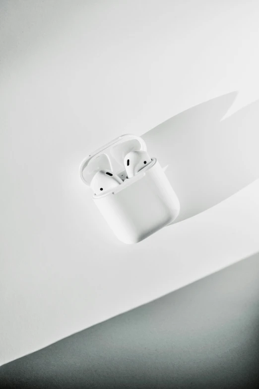 a pair of airpods resting upside down on a wall