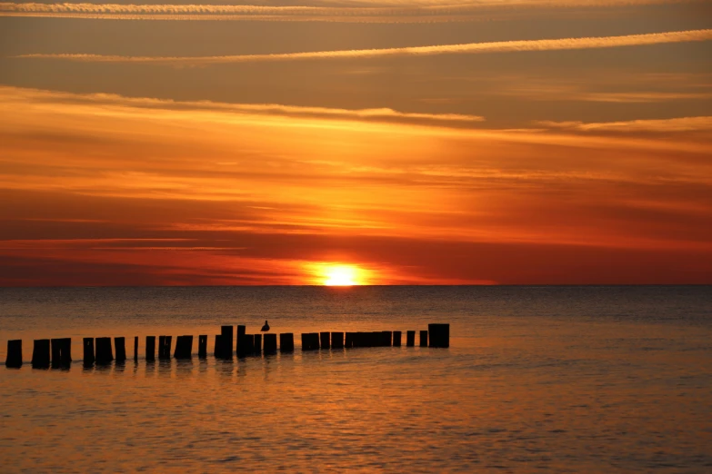 an image of the sun rising in the sky over the ocean