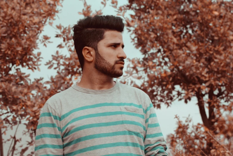 the man stands in front of some trees with a frisbee