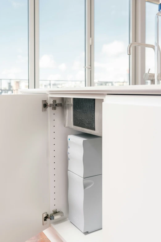 a sink with a window and a white cabinet